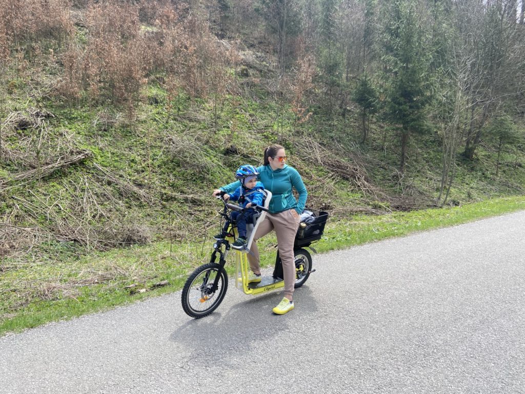 Žena s dieťaťom na elektrokolobežke v Ľubochnianskej doline.